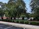 Community pool surrounded by green lawns, trees, and a parking area at 1527 Haywards Heath Ln, Apex, NC 27502