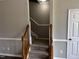 Carpeted staircase with wooden railing leading to upper level of home at 1527 Haywards Heath Ln, Apex, NC 27502