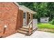 Brick home with wooden steps leading to a charming back entrance and well-maintained yard at 202 Crest Rd, Cary, NC 27513