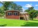 Charming brick home with a well-kept lawn, shaded by mature trees, and a inviting deck at 202 Crest Rd, Cary, NC 27513