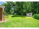 Spacious backyard with lush green grass, mature trees, storage shed, and a cozy deck at 202 Crest Rd, Cary, NC 27513