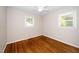 This cozy bedroom features hardwood floors, two windows, and a ceiling fan with lights at 202 Crest Rd, Cary, NC 27513