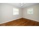 This bedroom features hardwood floors, ceiling fan, and multiple windows offering plenty of natural light at 202 Crest Rd, Cary, NC 27513