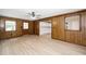 This large living room with wood walls has a view of the kitchen and access to the backyard at 202 Crest Rd, Cary, NC 27513