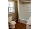 Bathroom featuring tile surround tub, vinyl floors, and a window for natural light at 207 2Nd St, Erwin, NC 28339