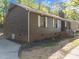 A well-maintained home with dark siding, white trim, brick foundation, and manicured landscaping at 216 Burkwood Ln, Raleigh, NC 27609