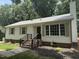 Well-maintained single-story home with white siding, brick foundation, and classic shutters on the windows at 216 Burkwood Ln, Raleigh, NC 27609