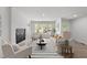 Sunlit living room with modern fireplace, neutral furniture, and large windows offering natural light at 216 Burkwood Ln, Raleigh, NC 27609