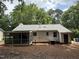 Back of house showing screened in porch with backyard and pine needle ground cover at 216 Burkwood Ln, Raleigh, NC 27609
