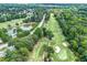 A scenic aerial shot of a golf course and pond, with lush green trees surrounding the meticulously manicured fairways at 2205 Landings Way, Raleigh, NC 27615