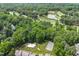 Aerial view of a community featuring a pool, tennis courts, a pond, and a beautiful golf course at 2205 Landings Way, Raleigh, NC 27615