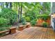 Outdoor wooden deck with built-in bench seating and lush green landscaping at 2205 Landings Way, Raleigh, NC 27615