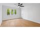 Light filled bedroom features wood-look flooring, a ceiling fan, and a large window at 2205 Landings Way, Raleigh, NC 27615
