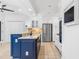 Modern kitchen featuring stainless steel appliances, white cabinets, and a blue island at 2205 Landings Way, Raleigh, NC 27615