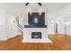 Spacious living room featuring hardwood floors and a white stone fireplace at 2205 Landings Way, Raleigh, NC 27615
