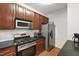 Well-lit kitchen featuring stainless steel appliances, gas range, microwave, and dark countertops at 222 Ashton Hall Ln, Raleigh, NC 27609