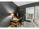 This home office has modern wood desk, dark accent wall, and lots of natural light at 222 Ashton Hall Ln, Raleigh, NC 27609