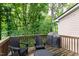 Outdoor deck featuring chairs and grill, surrounded by mature trees and lush greenery for privacy at 222 Ashton Hall Ln, Raleigh, NC 27609