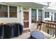 Back porch with grill and furniture, and a view of a tree-filled landscape at 222 Ashton Hall Ln, Raleigh, NC 27609
