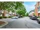 Street view of townhomes with mature trees. Cars parked on street at 222 Ashton Hall Ln, Raleigh, NC 27609
