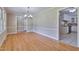 Dining room featuring hardwood floors, elegant lighting and trim, with view to kitchen at 3009 Wellington Dr, Rocky Mount, NC 27803