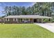 Charming brick home featuring a well-manicured lawn, covered parking, and a vibrant green door at 3009 Wellington Dr, Rocky Mount, NC 27803