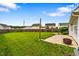 A spacious backyard with a lush green lawn, a wooden fence, and a patio with fire pit at 305 Slate Dr, Gibsonville, NC 27249