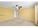 Bedroom features neutral carpet, ceiling fan, and yellow walls at 305 Slate Dr, Gibsonville, NC 27249