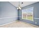 Cozy dining area with tiled floor, chair rail, modern light fixture, and large window at 305 Slate Dr, Gibsonville, NC 27249
