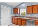 A kitchen sink area with a window and wood cabinets blends functionality with natural light to enhance the home at 305 Slate Dr, Gibsonville, NC 27249