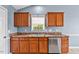 A kitchen sink with wood cabinets and natural light that offers an efficient design and lovely aesthetic appeal at 305 Slate Dr, Gibsonville, NC 27249