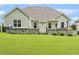 Back of the house features a stone patio and plenty of green grass at 347 Country Mill Way, Fuquay Varina, NC 27526