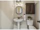 Powder room features pedestal sink, square mirror, and dark wood cabinet at 347 Country Mill Way, Fuquay Varina, NC 27526