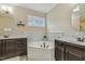 Bright bathroom features a soaking tub, a window, and double sink vanities at 347 Country Mill Way, Fuquay Varina, NC 27526