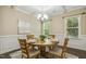 Dining room featuring hardwood floors, wainscoting, decorative chandelier, and abundant natural light at 347 Country Mill Way, Fuquay Varina, NC 27526