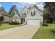 Charming two-story home with a manicured lawn and a long driveway leading to the two-car garage at 347 Country Mill Way, Fuquay Varina, NC 27526