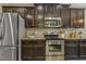 Modern kitchen with stainless steel appliances, dark wood cabinetry, and ample counter space for culinary creations at 347 Country Mill Way, Fuquay Varina, NC 27526