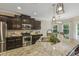 Kitchen showcases stainless steel appliances, dark cabinets, and a spacious granite countertop at 347 Country Mill Way, Fuquay Varina, NC 27526