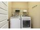 Well-lit laundry room with a white washer, dryer and ample shelving for organization at 347 Country Mill Way, Fuquay Varina, NC 27526