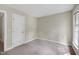 Simple carpeted bedroom with a door to the hall and one window letting in natural light at 3511 Shady Creek Dr, Durham, NC 27713