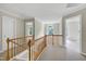 Bright hallway with natural light, featuring a wooden railing and views to multiple rooms at 3511 Shady Creek Dr, Durham, NC 27713