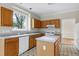 Kitchen featuring wood cabinetry, white appliances and an island, providing ample counter space at 3511 Shady Creek Dr, Durham, NC 27713