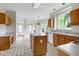 Kitchen featuring wood cabinets, a center island, white appliances and black and white tiled flooring at 3511 Shady Creek Dr, Durham, NC 27713