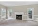 Inviting living room featuring a fireplace, neutral carpet, and access to a deck for outdoor living at 3511 Shady Creek Dr, Durham, NC 27713