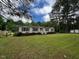 Quaint single-story home with green lawn, trees, and a white picket fence, perfect for Gathering living at 4040 Tyler Dr, Oxford, NC 27565