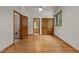 Open bedroom with light hardwood flooring, a ceiling fan, and two wood doors at 4110 Stoneycreek Rd, Chapel Hill, NC 27514