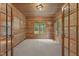 Cozy bedroom with wood paneled walls and ceiling, and a window with a view of the green yard at 4110 Stoneycreek Rd, Chapel Hill, NC 27514