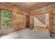 Wood paneled bedroom with carpeted floors featuring a view of the staircase and the green outdoors at 4110 Stoneycreek Rd, Chapel Hill, NC 27514