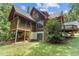 The back exterior of the home includes a screened porch, a deck, and a stacked stone chimney at 4110 Stoneycreek Rd, Chapel Hill, NC 27514