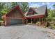 Lovely wood home with a gray roof and a spacious driveway, set amidst a serene wooded landscape at 4110 Stoneycreek Rd, Chapel Hill, NC 27514